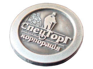 Stamped badge with the logo of the corporation SpetsTorg